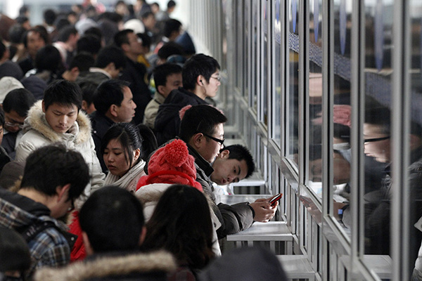 图为旅客在火车站站前广场售票处排队购票.视觉中国 资料图