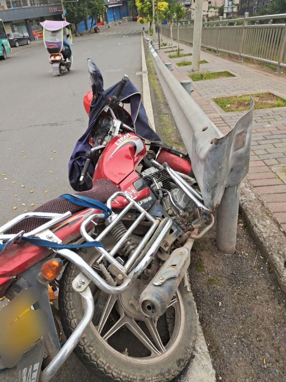 镇东中学上面,一辆摩托车撞在护栏上了